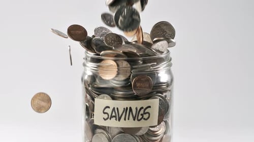Coins Falling into Savings Jar for Financial Concept