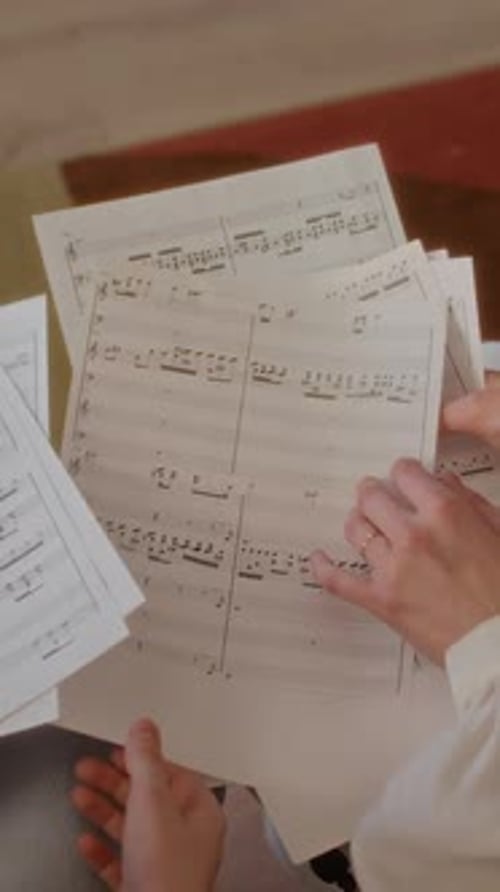 Child Pointing at Sheet Music during Lesson with Woman Teacher