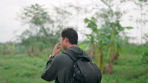 Slow motion: A tourist is walking along a forest road with a backpack.
