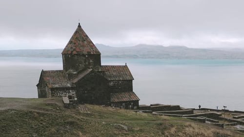 Person, die neben dem Kloster Sevanavank steht, Blick auf den Sevan-See
