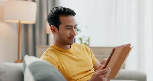 Home tablet, smile and relax man typing, texting and reading app post, media blog