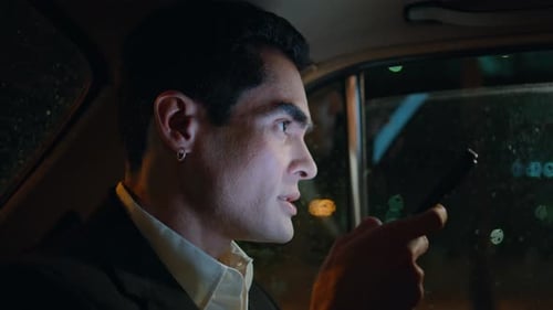 Young Adult Man Using Phone in Car at Night