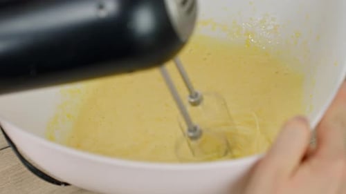 Mezclar yemas de huevo y azúcar en polvo con una batidora eléctrica para tiramisú