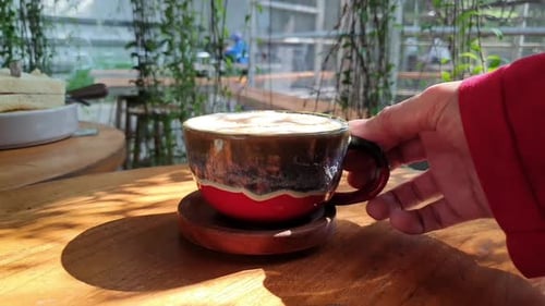A woman holding cup of coffee latte in Cafe