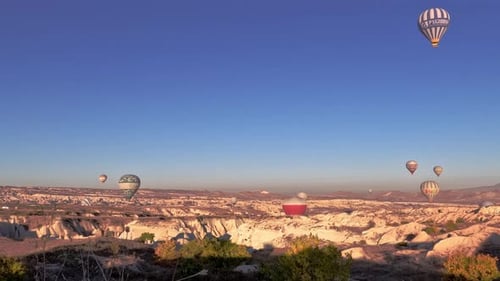Hot Air Balloons Floating Over Desert Landscape