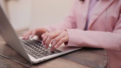 Adult Typing on a Laptop in Urban Setting