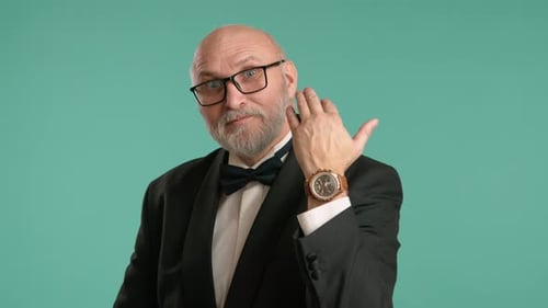 Man in Tuxedo Holding Up One Hundred Dollar Bill