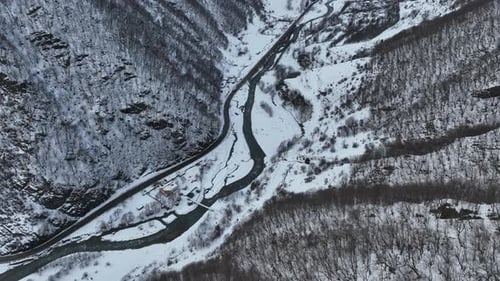 Aerial view of a frozen forest with snow covered trees at winter. Flight above beautiful snowy mount