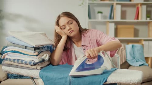 Weary Woman Ironing Clothing at Home