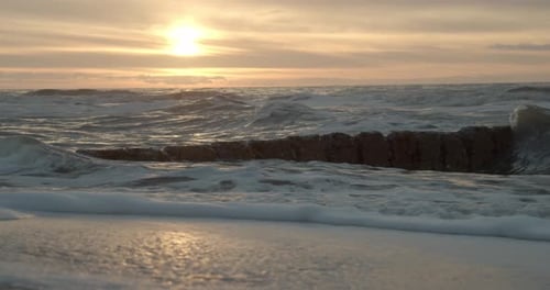 Waves Crashing on Sandy Beach at Sunrise