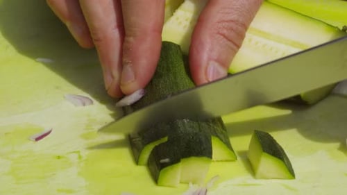 Hands Cutting Green Zucchini on Cutting Board