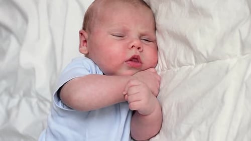 Adorable Infant Lying on White Blanket