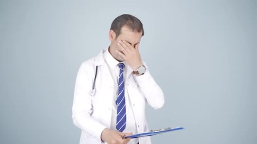 Doctor Taking Notes on Clipboard in Studio