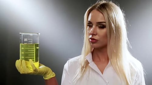 Woman Holds Beaker of Yellow Liquid
