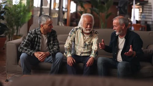 Three Mature Men Talking on a Couch