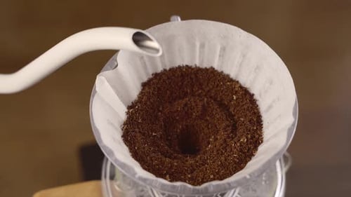 Drip coffee, close up footage pouring water over roasted.Man pouring water from the kettle into the