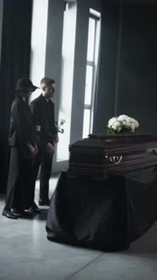 Mourning Woman and Man at Somber Funeral