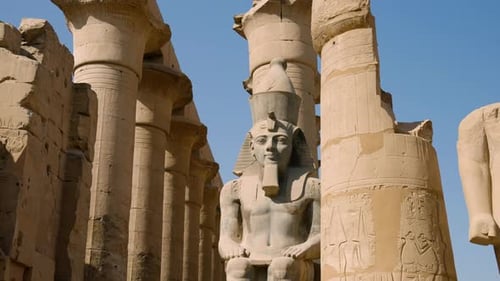 Huge Granite Statue Of Ramesses II Seated At The Front Of Columns In Luxor Temple, Egypt. Low Parall