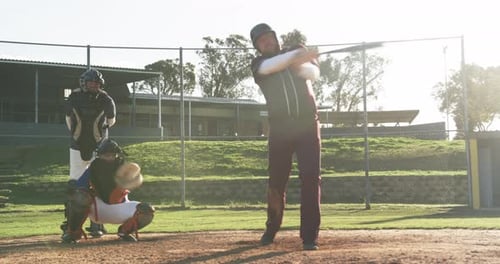 Playing baseball, batter holding bat while catcher and umpire ready on field