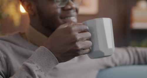 Man with Glasses Enjoying a Hot Drink at Home