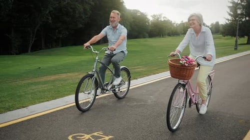 Senior Couple Riding Bicycles on Park Path