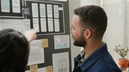 Un alegre desarrollador de UX presenta varios esquemas alámbricos al gerente de proyectos