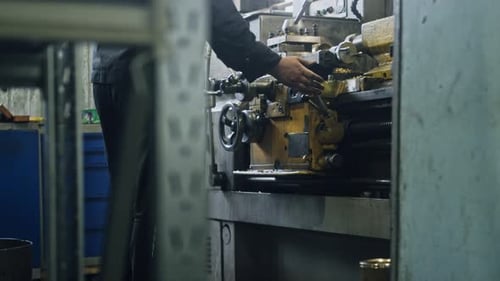Metal workshop worker operates industrial machine for precise manufacturing
