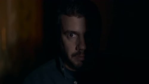 Man Aims Pistol in Dark Room