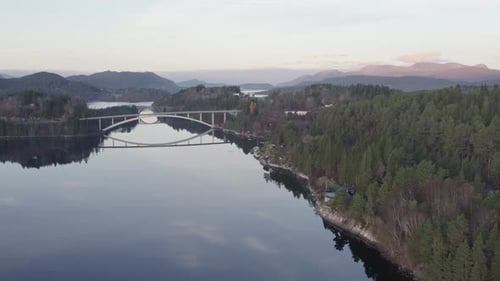 Panorama-Luftaufnahme einer modernen Bogenbrücke über einen ruhigen See