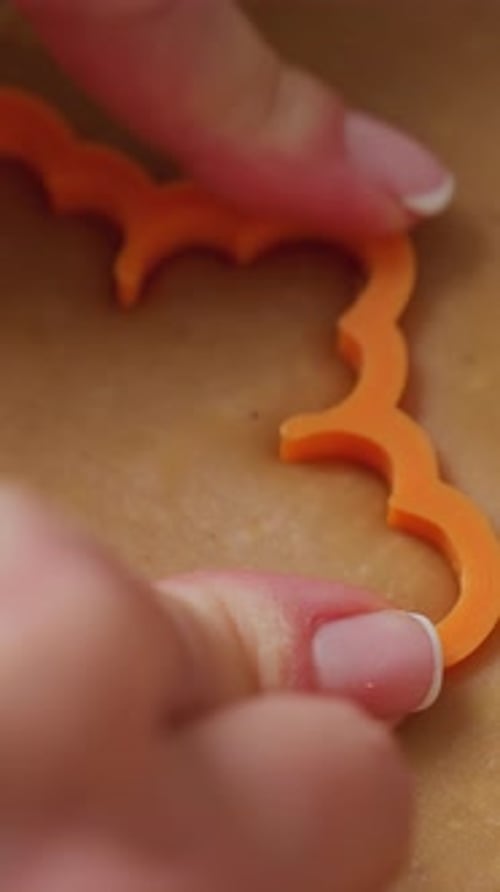 Cutting Cookies with shaped cutter on Dough, Close-Up