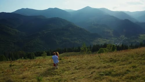 Pareja bailando contra impresionantes montañas, panorama soleado, día de verano, vista al parque nacional