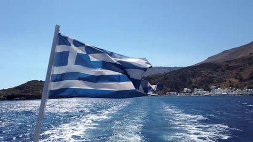 Greek flag on a boat leaving Loutro