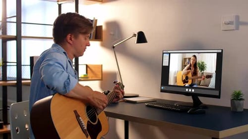 Man takes guitar lesson online with young woman