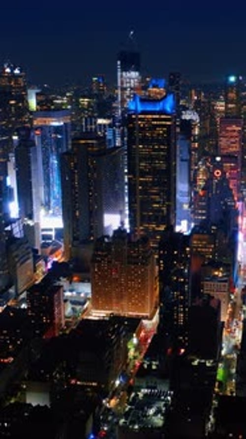 Bright light on the street at the foot of skyscrapers. Never sleeping New York filled with lights