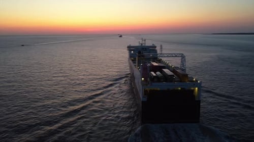 Aerial drone vew of cargo boat near port of Liverpool Great Britain at sunset, slow motion
