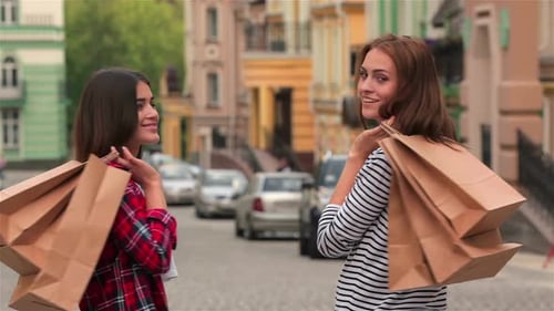 Filles avec des sacs de courses dans la rue de la ville