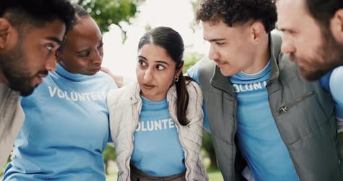 Group of Adults Huddle Wearing Volunteer T-Shirts