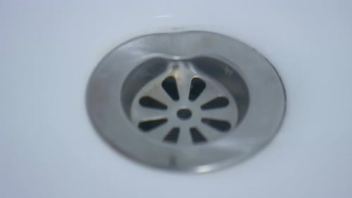 um antigo orifício de drenagem da pia está drenando a água