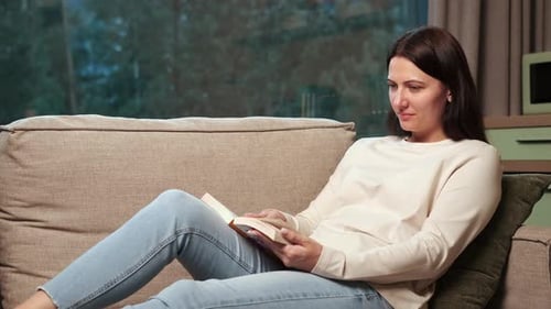 Woman Reading a Book on the Couch