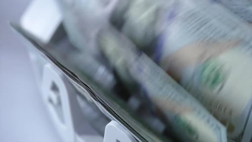 Counting mechanism processing one hundred dollar bills. Investment capital operations concept.