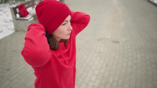 Lady Performing Hand Stretch Outdoors in Winter Fitness Routine with Snowcovered Park
