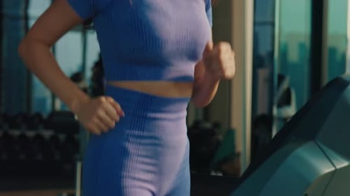 Woman in Athletic Wear Runs on Treadmill at Gym Closeup