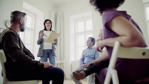 People sitting in circle for group discussion indoors