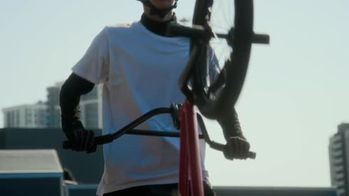 Young BMX Cyclist Riding Bike, Taking Off Helmet and Posing for Camera