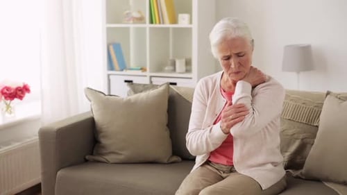 Senior Woman Massaging Sore Elbow at Home