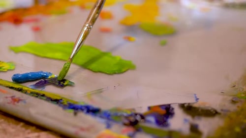 artist mixing paint on a palette