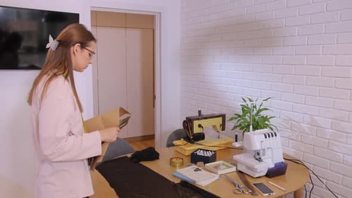 Woman Prepares Sewing Patterns in Bright Room