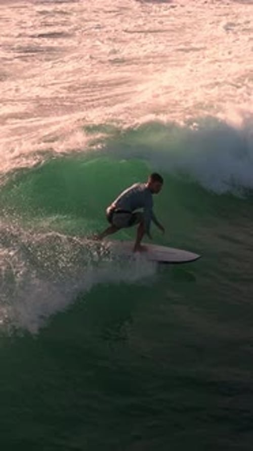 Surfer riding ocean wave in vertical video