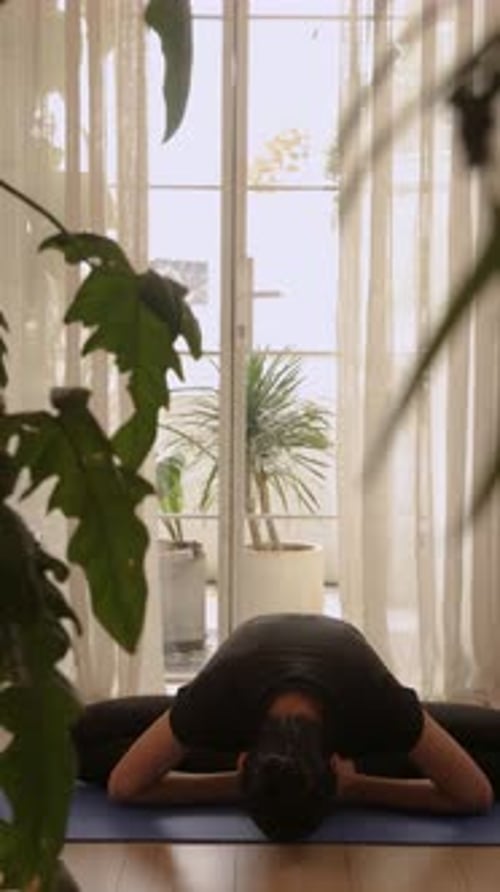 Femme asiatique faisant du yoga avec pose de papillon à la maison