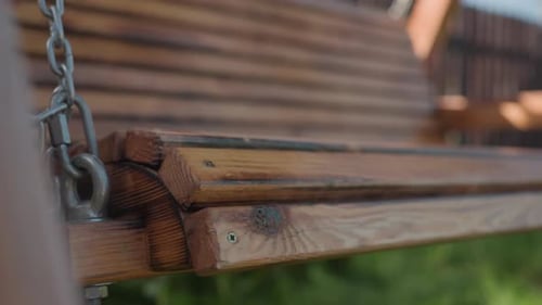 Close Up of Metal Chain and Wood Joint on Gently Swaying Outdoor Swing Seat